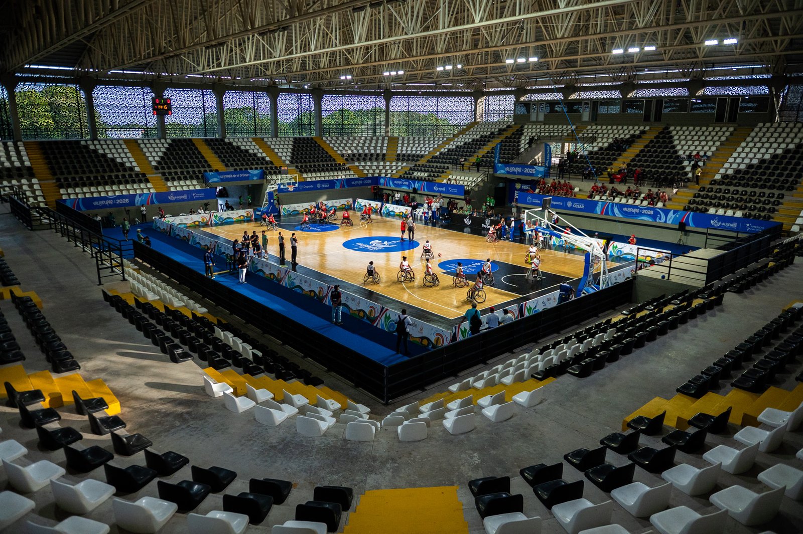 Cancha cubierta con partido de baloncesto en silla de ruedas